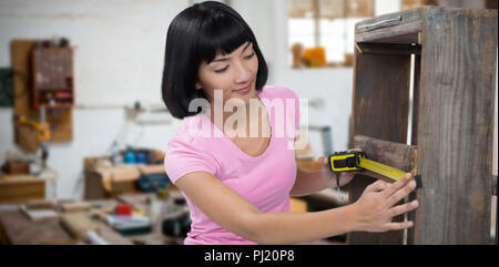 Das zusammengesetzte Bild der Frau Möbel mit Maßband messen Stockfoto