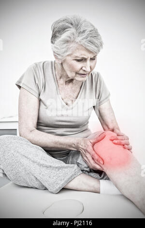Das zusammengesetzte Bild der älteren Frau mit ihren Händen auf eine schmerzhafte Knie Stockfoto