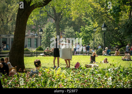 New York, USA. 3. September 2018. New Yorker und Besucher backen in der Sonne auf dem Rasen im Washington Square Park in Greenwich Village in New York auf der inoffiziellen Ende des Sommers, Arbeitstag, Montag, 3. September 2018. Hohe Luftfeuchtigkeit und bratenen Temperaturen garantieren eine unbequeme Tag in New York als Wärme Beratung ist. (© Richard B. Levine) Credit: Richard Levine/Alamy leben Nachrichten Stockfoto