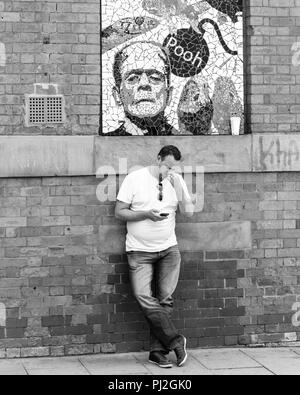Amüsante Bild eines Mannes, der seine Nase Holding unter einem Plakat mit dem Wort pfui in Manchester Stockfoto
