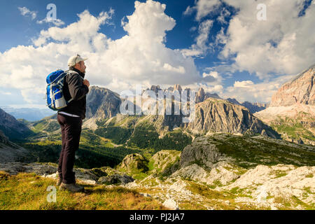 In der wunderschönen alpinen Landschaft eingebettet, ein Mann bewundert die hochalpine Landschaft mit Bergen und bewölktem Himmel. Stockfoto