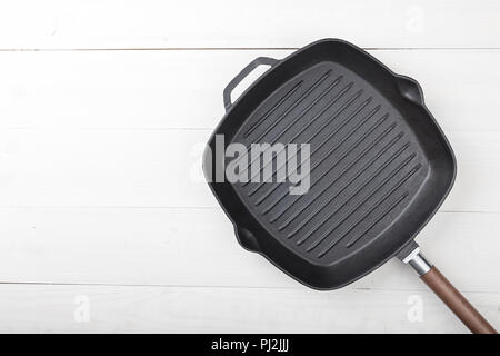 Leere Grill Pfanne auf einem hölzernen Hintergrund, Platz zum Schreiben Rezept Stockfoto