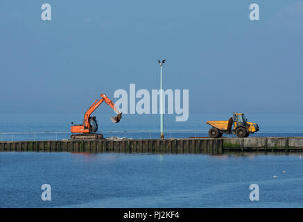 Bau digger mit Kipper Lkw auf fähre Helling, Knott am Meer, Lancashire, Großbritannien Stockfoto