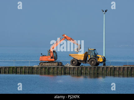 Bau digger mit Kipper Lkw auf fähre Helling, Knott am Meer, Lancashire, Großbritannien Stockfoto