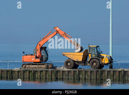 Bau digger mit Kipper Lkw auf fähre Helling, Knott am Meer, Lancashire, Großbritannien Stockfoto