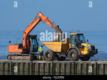 Bau digger mit Kipper Lkw auf fähre Helling, Knott am Meer, Lancashire, Großbritannien Stockfoto