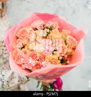 Schönen Blumenstrauß mit verschiedenen tpink Blumen in der Frau die Hände. Schön subtil zarten rosa Blumenstrauß mit Rosen, Dianthus, Hypericum, Nelke. Flache DOF Stockfoto
