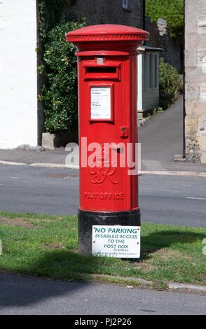 Ein Briefkasten im Great Longstone, Derbyshire mit einer Benachrichtigung bitten um keine Parkplätze vor der Behindertenparkplätze zu ermöglichen. Stockfoto