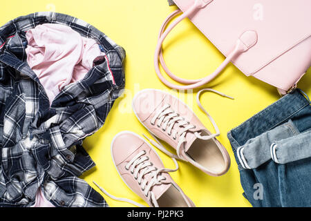 Woman Fashion Tuch set - rosa Schuhe, Top und Jeans auf gelben Hintergrund. Ansicht von oben kopieren. Stockfoto