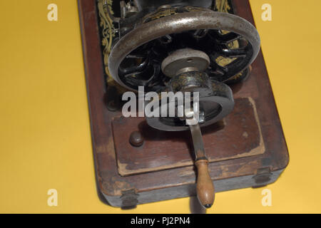 Alte Nähmaschine hinten drehenden Close-up. Anmutige Rad- und einfache Holzgriff. mit Freistellungspfad Stockfoto