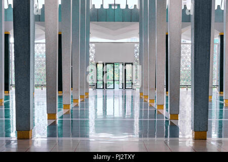 Langen Korridor zwischen vielen Spalten mit offenen Türen am Ende, symmetrischen moderne Halle in nationalen Moschee (Masjid Negara), Kuala Lumpur, Malaysia. Aber Stockfoto