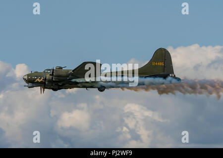 Sally B, die erhaltenen Boeing B-17 Flying Fortress Bomber trailing Rauch während der Anzeige an Dunsfold Wings & Wheels, Großbritannien am 25. August 2018. Stockfoto