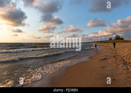 Oval Strand bei Sonnenuntergang mit leichten Wellen und Wolken im blauen Himmel - Saugatuck, MI Stockfoto