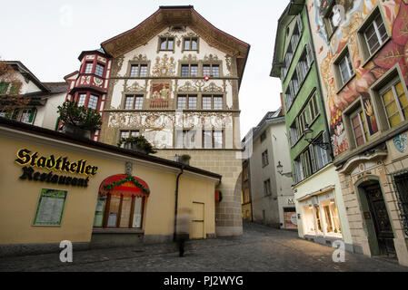 Luzerner enge Gassen öffnen sich zu kopfsteingepflasterten Plätzen mit farbenfrohen, mit Fresken geschmückten Stadthäusern in der Schweiz. Stockfoto