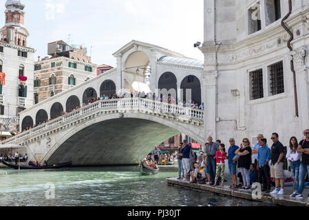 Ruderer und Zuschauer schweben nach unten und entlang des Canal Grande für die jährliche Historische Regatta in Venedig, Italien sammeln Stockfoto