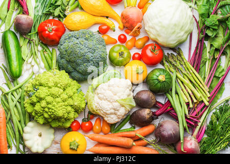Buntes Gemüse aus ökologischem Hintergrund auf weiße Holztisch, gesunde Hintergrund, Brokkoli Blumenkohl Tomaten Frühlingszwiebeln Gurken Karotten, rote Rüben, Ansicht von oben, selektiver Fokus Stockfoto