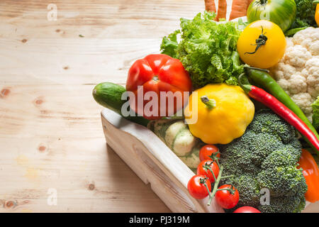 In der Nähe von frischem organischen bunte Gemüse in einem weißen Fach auf Holz Kiefer Tabelle, Ansicht von oben, Kopieren, selektiven Fokus Stockfoto