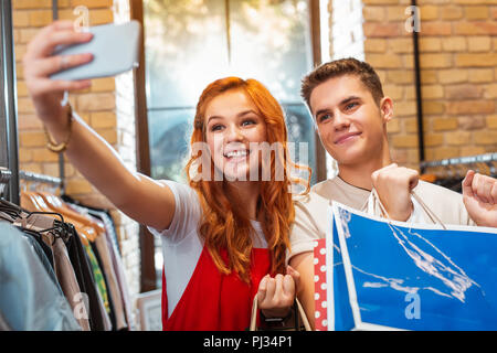 Schöne Frau, die mit ihrem Freund selfie beim Einkaufen tun Stockfoto