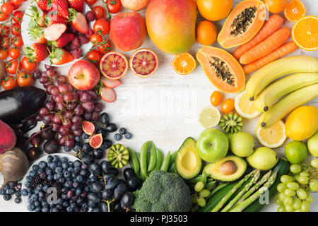 Das gesunde Essen, varieity von Obst und Gemüse in Regenbogenfarben an der aus weissen Tisch in einem Rahmen mit Kopie Raum angeordnet, senkrechte Draufsicht, selektiver Fokus Stockfoto