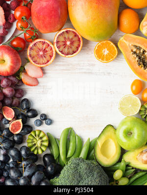 Das gesunde Essen, varieity von Obst und Gemüse in Regenbogenfarben an der aus weissen Tisch in einem Rahmen mit Kopie Raum angeordnet, senkrechte Draufsicht, selektiver Fokus Stockfoto