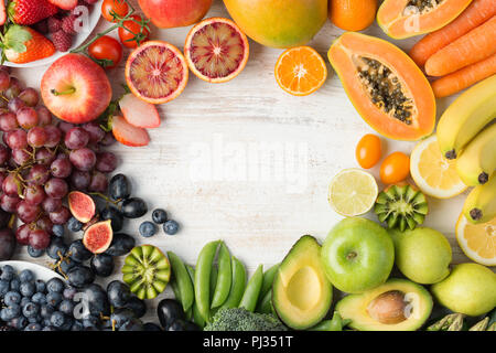 Das gesunde Essen, varieity von Obst und Gemüse in Regenbogenfarben an der aus weissen Tisch in einem Rahmen mit Kopie Raum angeordnet, senkrechte Draufsicht, selektiver Fokus Stockfoto