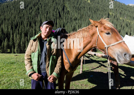 Altyn-Arashan, Kirgisistan, 14. August 2018: Eine junge Kirgisische stolz posiert vor seinem Pferd in das Tal von Altyn-Arashan in Kirgisistan Stockfoto