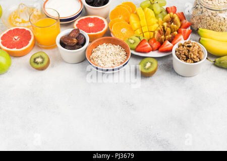 Ansicht von oben gesundes Frühstück mit Hafer, Vielfalt der Früchte, Erdbeeren, Mango, Trauben, serviert auf der weissen Tisch, selektiver Fokus Stockfoto