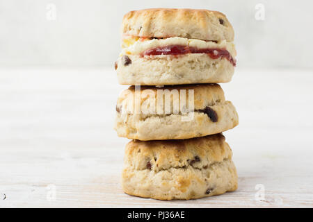 In einer drei Scones mit Marmelade und Sahne stack, auf den Teller, auf dem weißen Holztisch, selektiver Fokus kopieren Platz für Text Stockfoto