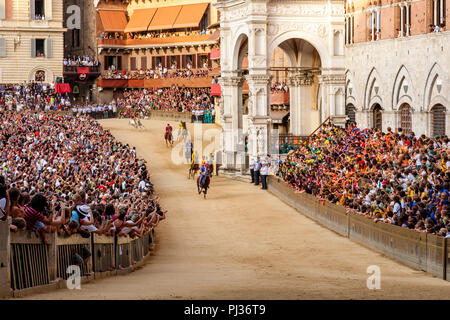 Jockeys gekleidet in bunten Kostümen, vertreten ihre Contradas nehmen Sie teil an einem der sechs Trial Rennen, die vorangehen, der Palio, Siena, Italien Stockfoto