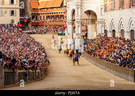 Jockeys gekleidet in bunten Kostümen, vertreten ihre Contradas nehmen Sie teil an einem der sechs Trial Rennen, die vorangehen, der Palio, Siena, Italien Stockfoto