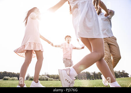 Kleben. Familie von vier Hände halten tanzen im Kreis auf einem gra Stockfoto