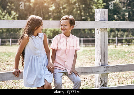 Freundschaft. Kleine Jungen und Mädchen zusammen gehen im Freien leanin Stockfoto