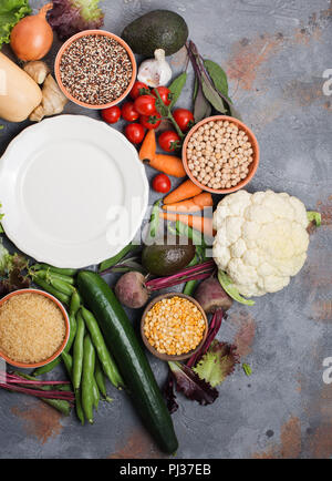 Gemüse und Getreide, mit Aus weiße Platte, Brokkoli, Kürbis, Bohnen, Tomaten, Möhren, Avocado, Ansicht von oben, vertikale selektiven Fokus Stockfoto