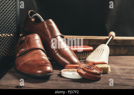 Schuhe aus Leder und Schuhcreme Ausrüstung auf einer hölzernen Zusammensetzung Stockfoto