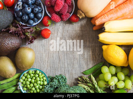 Rahmen aus rainbow Obst und Gemüse auf dem grauen Holz- Tabelle, Ansicht von oben, kopieren Platz für Text, selektiver Fokus Stockfoto