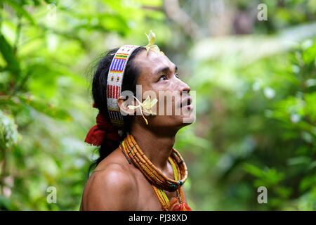 Portrait eines jungen Schamanen mit Blumen und Schmuck im dichten Dschungel, Mentawai, Siberut, Sumatra, Indonesien Stockfoto