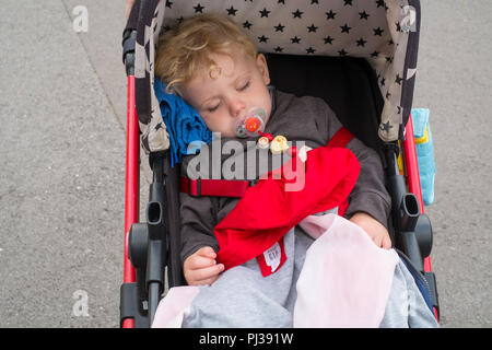 Erschöpfter zweijähriger Junge im Paultons Park, Ower, Romsey, Southampton, England, Großbritannien. Stockfoto