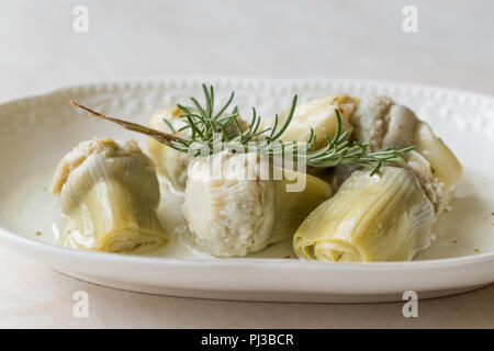 Eingelegte Artischockenherzen mit Rosmarin marinierte in der Platte. Ökologische Lebensmittel. Stockfoto