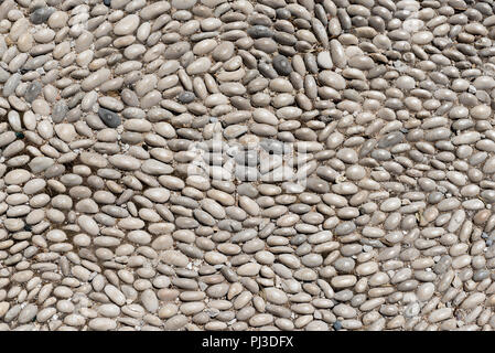 Textur und Hintergrund mit kleinen Kieselsteinen. Bürgersteig auf der Straße in Rhodos. Griechenland Stockfoto