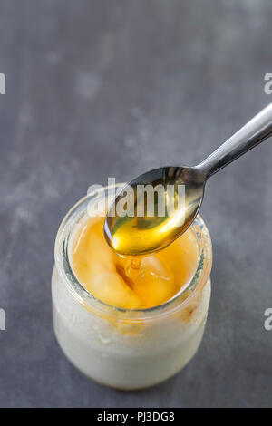 Honig Joghurt. Joghurt und Honig im Glas auf slatte Hintergrund Stockfoto