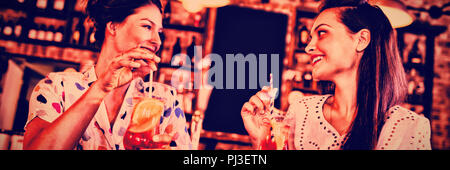 Zwei junge Frauen, die Cocktail Drinks Stockfoto