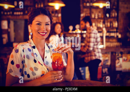 Porträt der jungen Frau, die Cocktail trinken Stockfoto