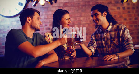 Junge Freunde toasten Bierkrüge Stockfoto