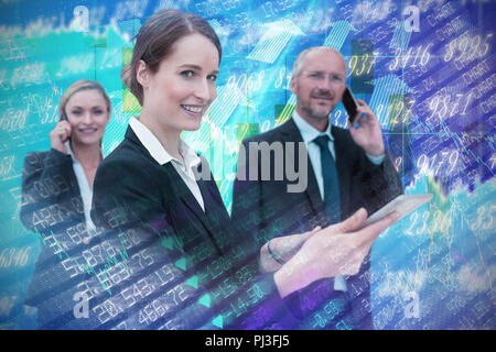 Das zusammengesetzte Bild der Unternehmerin mit Tablette während Kollegen am Telefon sprechen im Hintergrund Stockfoto