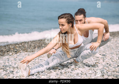 Dehnen vor dem täglichen jogging am Strand Stockfoto