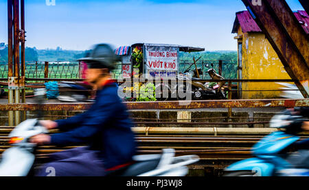 In motion Unschärfe der Motorradfahrer auf der Red River Bridge mit einer Frucht stand ganz im Hintergrund. Stockfoto