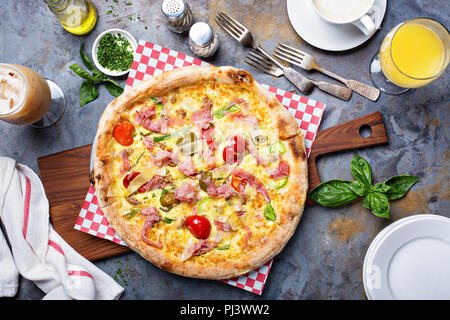 Frühstück Pizza mit Rührei, Schinken, Peperoni und Tomaten Stockfoto