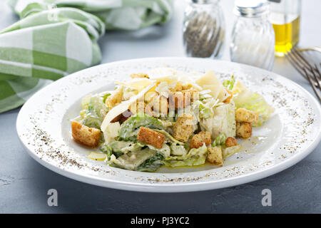 Ceasar Salat zum Mittagessen mit Salz und Pfeffer auf dem Tisch Stockfoto