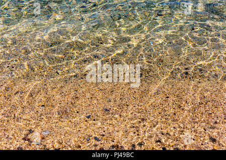 Hintergrund Der transparente klare Wasser des Meeres, schillernden Sonnenlicht auf das Meer unten spiegeln Stockfoto