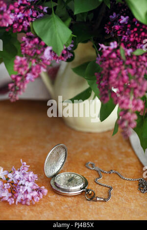 Antike Taschenuhr, Blume vor Holz- Hintergrund Stockfoto